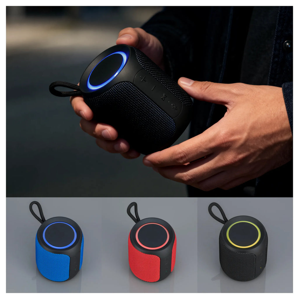 Henkilö pitää kädessään Expediton-Bluetooth-kaiutinta, jonka yläosassa on hohtava pyöreä valo. Kaiutinta on esillä kolmessa eri värivaihtoehdossa: sinisenä, punaisena ja mustana.